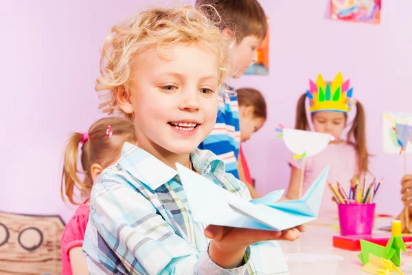 Blond handsome boy shows origami — Stock Photo, Image