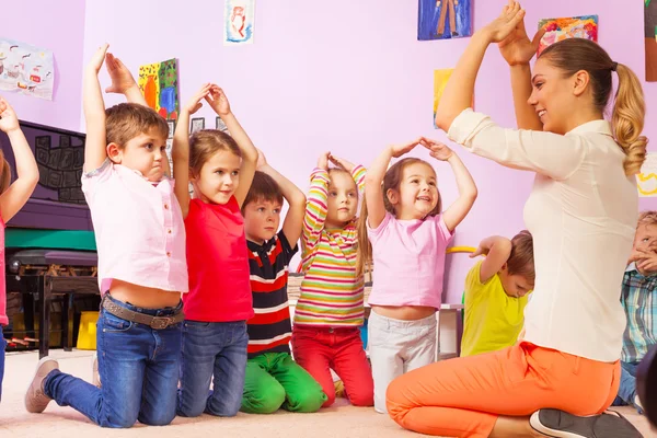 Kinder wiederholen Geste nach dem Lehrer — Stockfoto