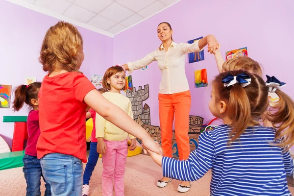 Kinderen spelen roundelay rond meisje — Stockfoto