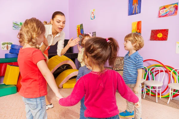 Viele Kinder klatschen mit Lehrerin in die Hände — Stockfoto