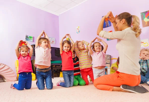 Niños muestran casa con la mano — Foto de Stock