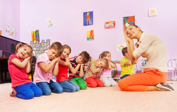 Kids in group play game pretending to sleep — Stock Photo, Image