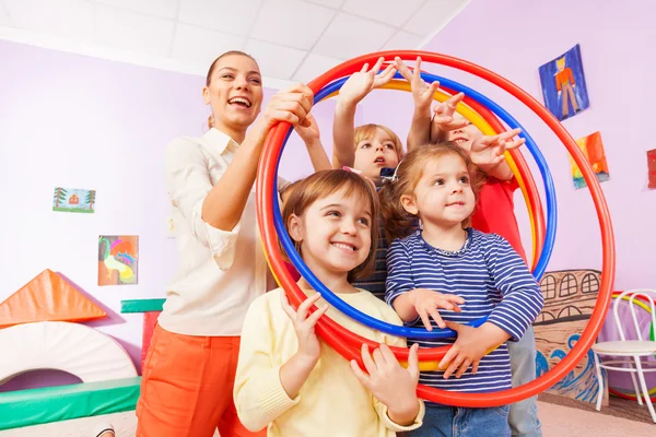 Kinder mit Lehrer schauen durch Reifen — Stockfoto