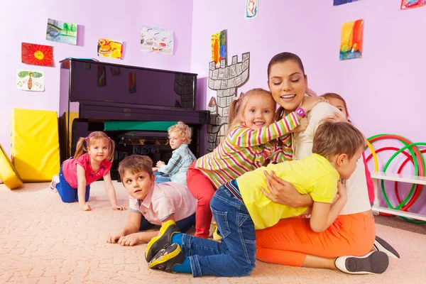 Grupo de niños niños niños y niñas abrazo maestro — Foto de Stock