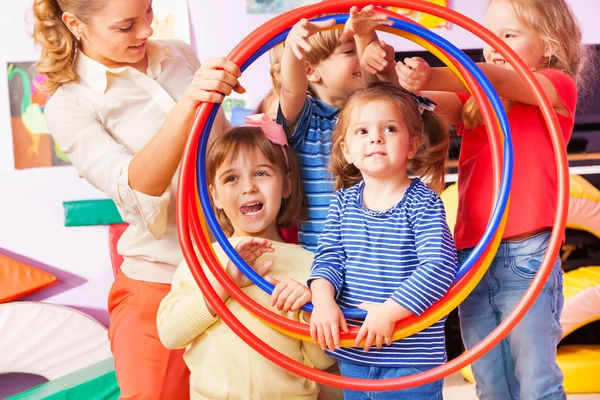 Kinderen jongens en meisjes kijken hoewel hoepel — Stockfoto