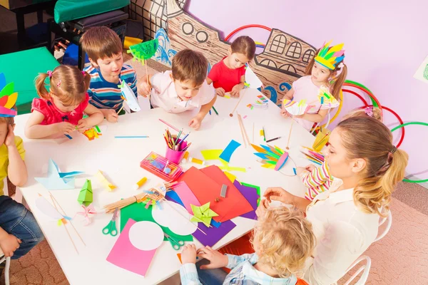 Grupo de niños y profesor por mesa —  Fotos de Stock