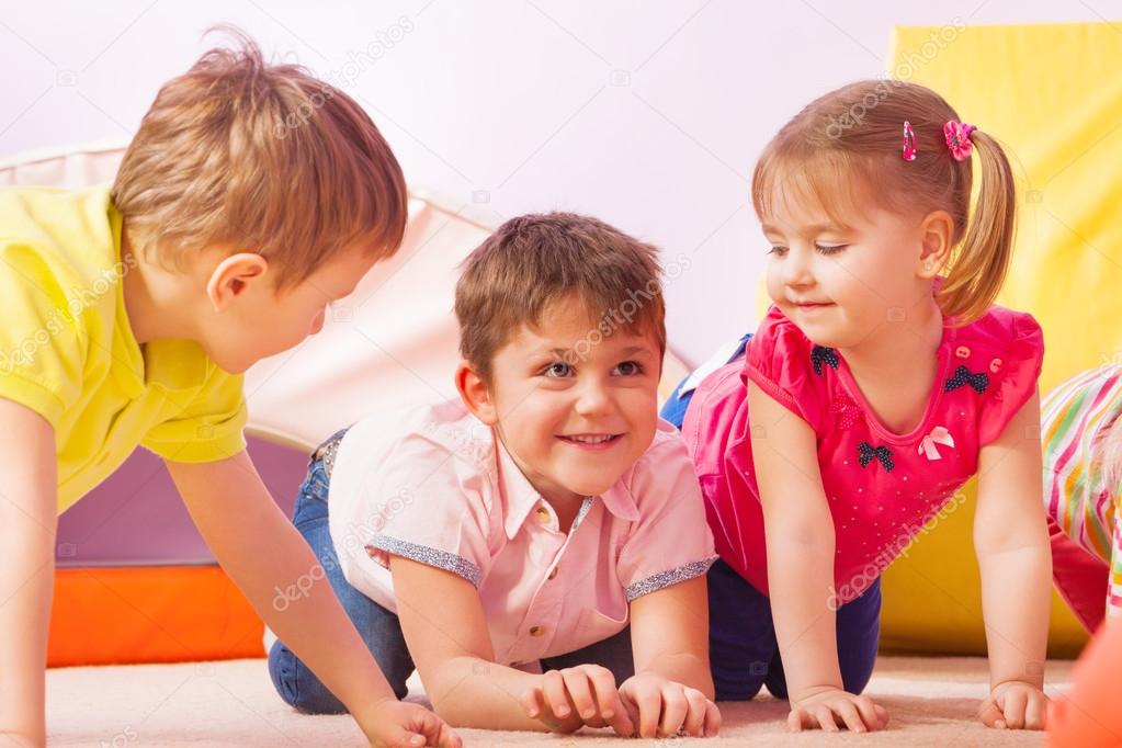 Group of kids crawl together and smile