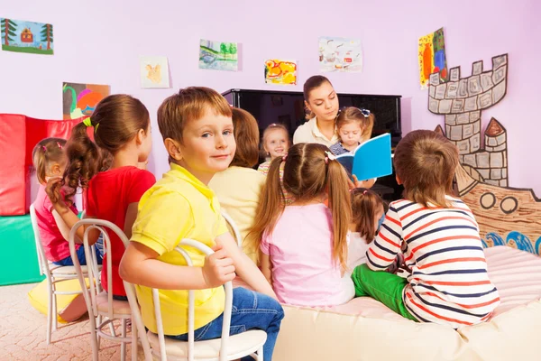 Kids Luister naar leraar verhalen lezen van boek — Stockfoto