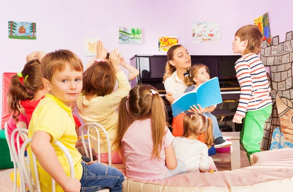 Dzieci słuchać nauczycieli czytania książki w klasie — Zdjęcie stockowe