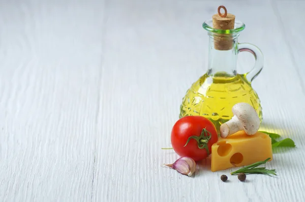 Oliwa z oliwek, sera i warzyw na biały drewniany stół. — Zdjęcie stockowe