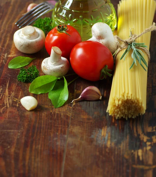 Spaghetti, tomater, svamp och örter på ett gammalt träbord. — Stockfoto