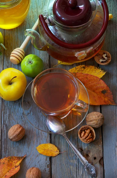 刚煮好的茶、 苹果、 蜂蜜和秋天的落叶。老木桌上的食物. — 图库照片
