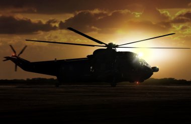Havaalanı günbatımı sırasında askeri helikopter