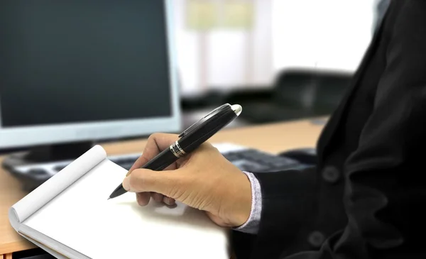 Man writing on notepad in the office — Stock Photo, Image