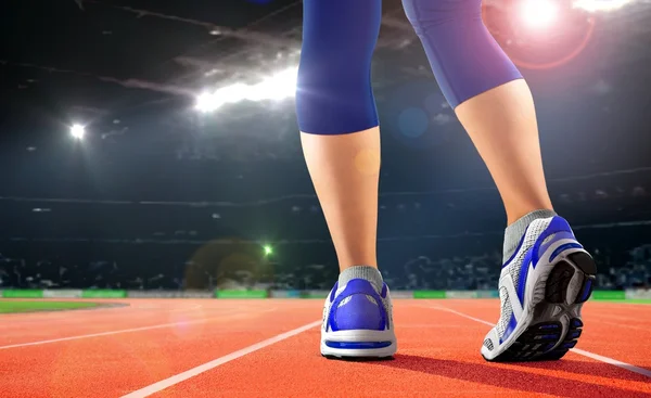 Legs of athlete on running track in the stadium — Stock Photo, Image