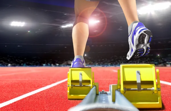 Jambes d'athlète sur bloc de course dans le stade — Photo