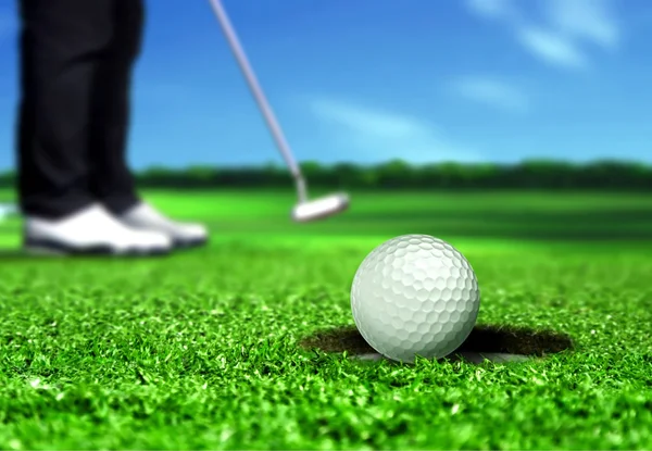 Golf topu deliğe koyarak — Stok fotoğraf