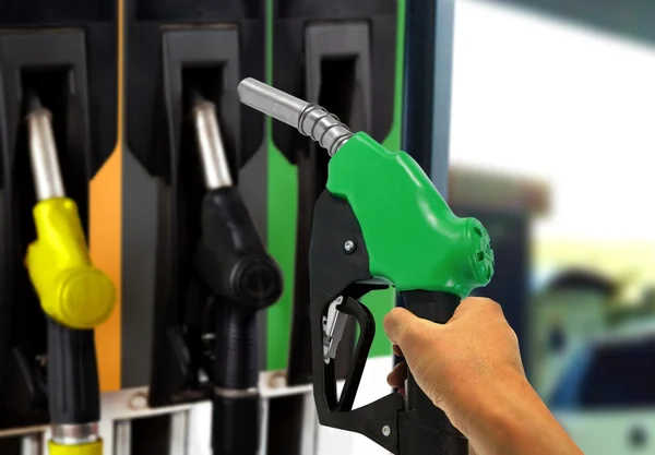 Mão segurando bocal de gás no posto de gasolina — Fotografia de Stock