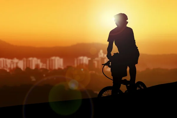 Mountainbiker rusten tijdens het kijken naar de zonsondergang — Stockfoto