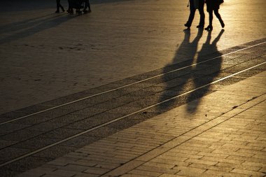  Meydanda yürüyen bir kişinin gölgesinin akşam manzarası                              