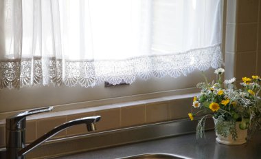 Mutfakta pencere ve perdeleri olan çiçek süslemeleri                               