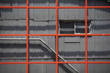 Binanın duvarında kırmızı çelik çerçeve var.                               