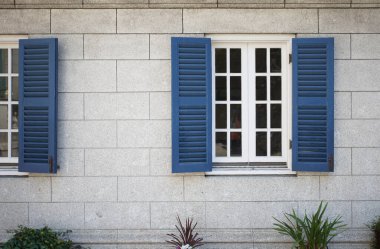 Binanın duvarında mavi fırtına penceresi                               