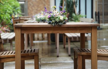 Bahçedeki ahşap bir masada çiçekler                               