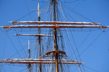 Açık bir gökyüzünde limanda bir yelkenli gemisinin direği.                               