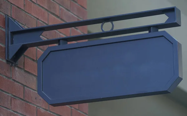 Mağazanın girişindeki duvarda boş bir tabela asılı.                               