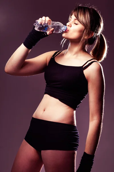 Young sports woman drinks water — Stock Photo, Image