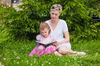 Küçük kız ve annesi bir kitap okuma