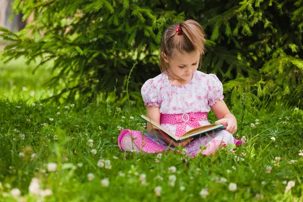 Meisje is lezen op het gras — Stockfoto