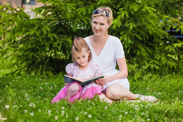 Küçük kız ve annesi bir kitap okuma — Stok fotoğraf