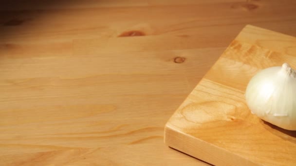 Tre cipolle su una tavola di legno — Video Stock