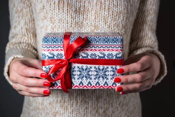 Woman in a light sweater holding Christmas present. gift delivery concept — Stock Photo, Image
