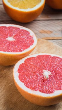 Tahta bir masada dilimlenmiş turunçgil ve greyfurt.