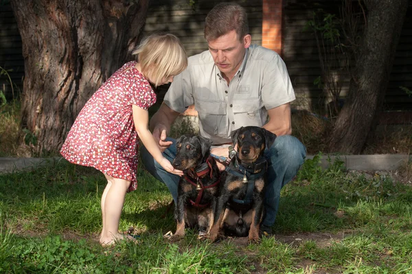 The father shows to the daughter as it is necessary to treat dog — Stock Photo, Image