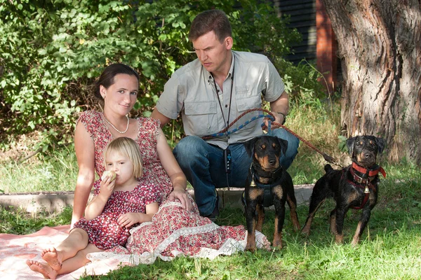 The man with two dogs protects the woman with the child — Stock Photo, Image