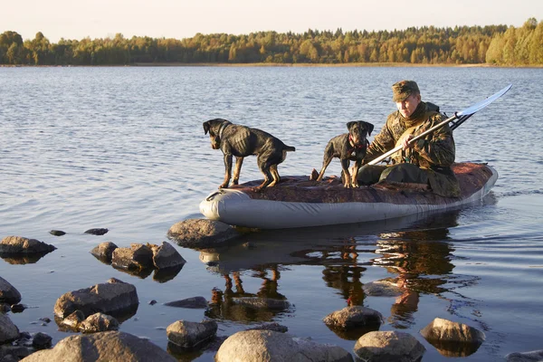 The hunter with two dogs moors to the coast — Stock Photo, Image