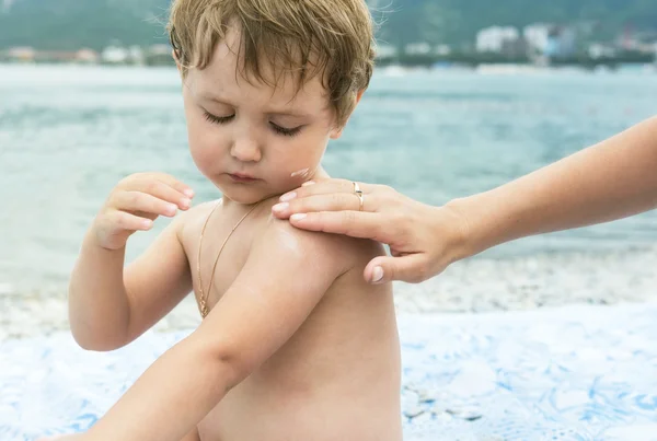 Crema protettiva per il bambino su spiaggia — Foto Stock