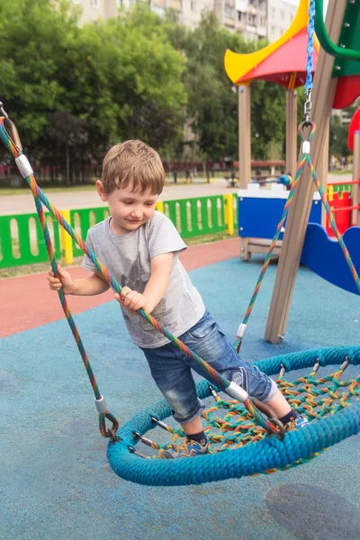 Čtyřleté dítě na koni stojící na kulaté swing — Stock fotografie