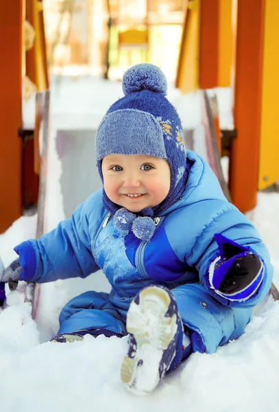 Criança alegre no parque infantil no inverno — Fotografia de Stock