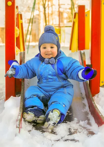 Glückliches Kind auf Kinderspielplatz im Winter — Stockfoto