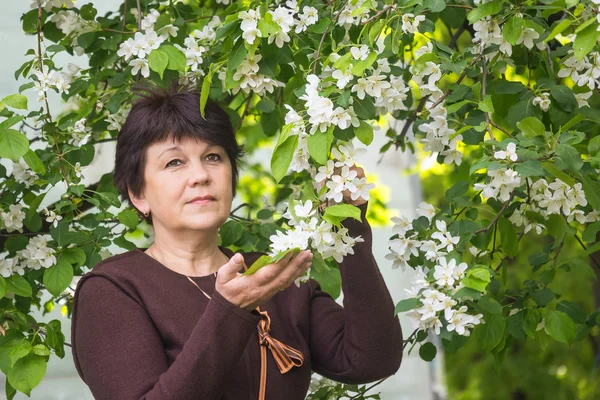 Kvinna mot blommande äppelträd — Stockfoto