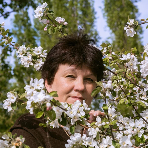 Porträtt av mogen kvinna bland äppelträd — Stockfoto