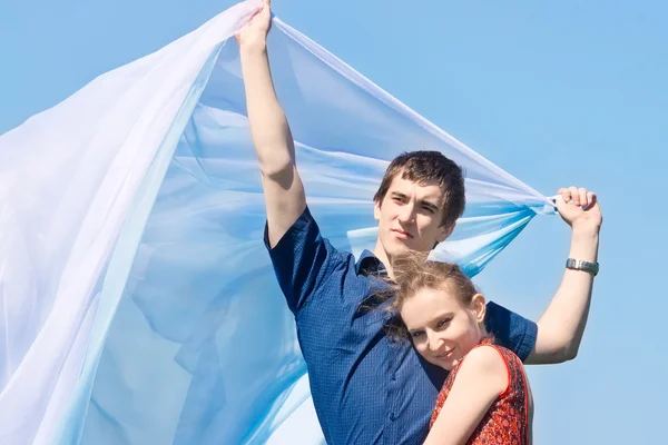 คู่หนุ่มที่มีผ้าพันคอสีขาวกับท้องฟ้าสีฟ้า — ภาพถ่ายสต็อก