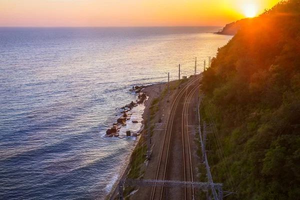 Järnväg på seacoast lämnar på sunset — Stockfoto