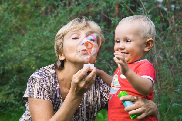 Nagymama és a gyerek a szappanbuborékok — Stock Fotó