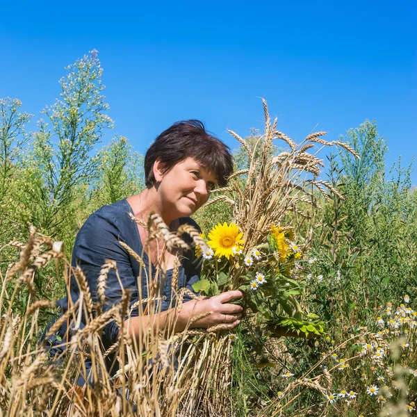 Donna con orecchie e girasoli in campo — Foto Stock